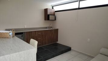 A compact kitchen with dark wooden cabinets, a built-in sink, and a countertop.