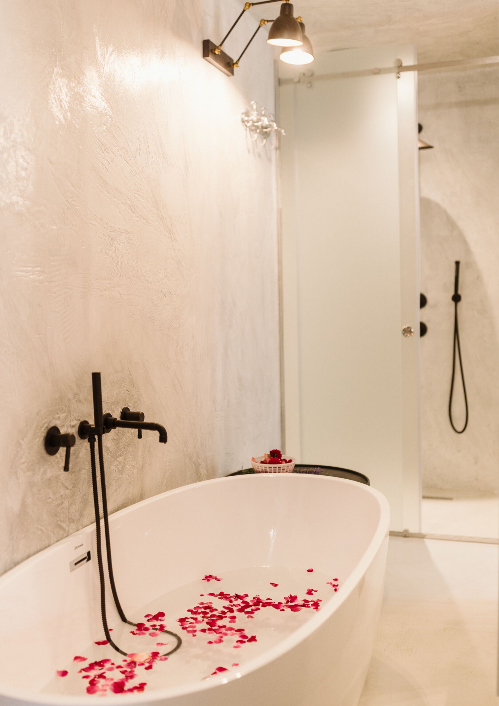 A modern bathroom with a freestanding bathtub, a shower, and a towel rack.