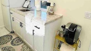A compact kitchen with a refrigerator, sink, and coffee maker on a small table. - Light, bright & clean, studio guest suite with private entrance and hot tub! (Redmond)