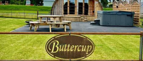 A wooden building with a sign reading "Buttercup" in front.