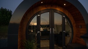 A modern building with a circular entrance and wooden interior. - Bedwen -  Glamping pod with Hot Tub sleeping 2 guests (Welshpool)