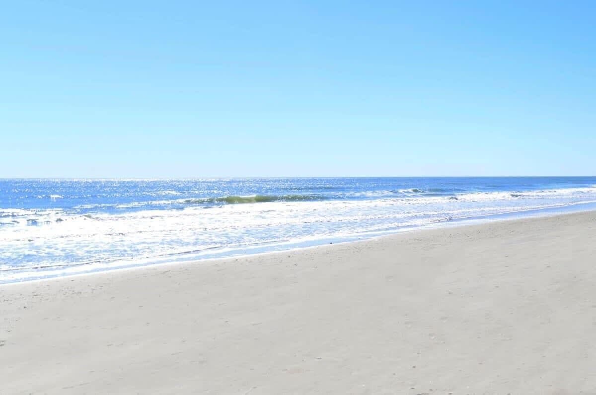 A beach with a clear sky and calm sea.