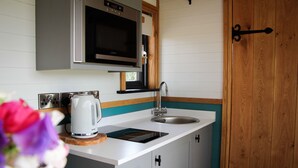 A compact kitchen with a microwave, kettle, and sink. - Cwm Cariad  -  Shepherds Hut with Hot Tub Sleeping 2 guests, Pet Friendly (Knighton)