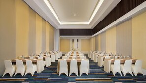 A conference room with rows of tables and chairs, a patterned carpet, and a neutral color scheme. - Howard Johnson by Wyndham Pekalongan Indonesia (Pekalongan)