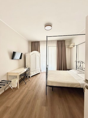 A bedroom with a bed, a desk, a wardrobe, and a television. - Porta Amari (Palermo)