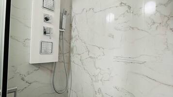 Comfort kamer | Badkamer | Een douche, een hydromassagedouche, een haardroger, pantoffels