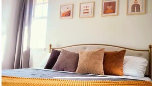 A neatly made bed with a golden blanket, a wooden headboard, and three framed artworks on the wall. - Family Friendly 3BR w/Mt views, Close to Beach (Waianae)