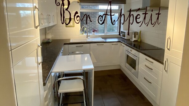 A modern kitchen with white cabinets, a stainless steel countertop, and a built-in oven. - Luxurious Living in the Heart of Bromley (Bromley)