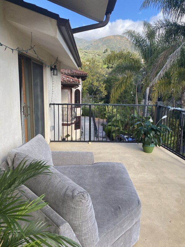 Relax on the balcony with a sofa and enjoy the view of lush greenery and distant mountains.