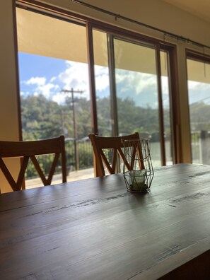 Enjoy meals with a mountain view from this dining area featuring a table and chairs.