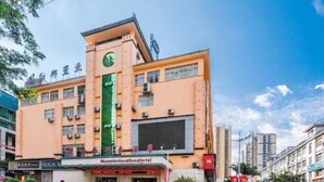 Een hotel met een groene verticale streep, meerdere verdiepingen en een klokkentoren.