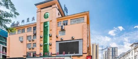 A hotel with a green vertical stripe, multiple floors, and a clock tower.
