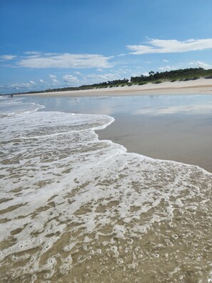 A beach with gentle waves, a clear sky, and distant buildings. - 3BR/2.5BA Home - 2 Queen+2 Single Bds - North Jax (Jacksonville)