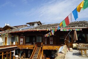 A traditional building with a wooden staircase, a satellite dish, and a flag. - Old Yard Inn (Shangri-La)