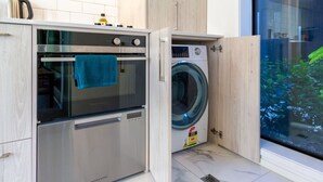 Una cocina funcional con horno integrado y lavadora.