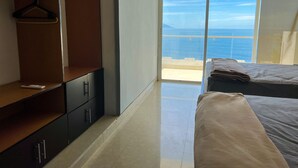 A bedroom with a large sliding glass door leading to a balcony with a view of the sea. - Incredible condo with panoramic views of the sea and mountains (Puerto Vallarta)