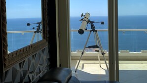 A telescope on a balcony with a view of the ocean. - Incredible condo with panoramic views of the sea and mountains (Puerto Vallarta)