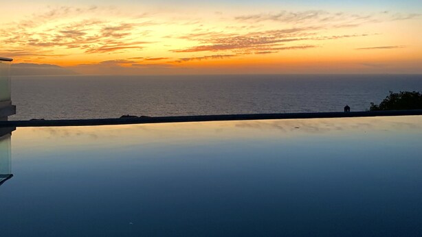 A clear view of a swimming pool with a sunset in the background. - Incredible condo with panoramic views of the sea and mountains (Puerto Vallarta)