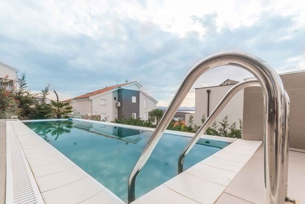 Relax by the pool surrounded by a deck and residential buildings.