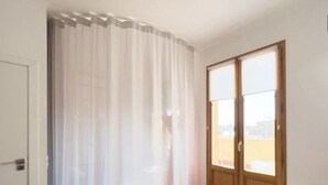 A room with a large window, a door, and a chair. - Diamond Penthouse & Terrace (Barcelona)