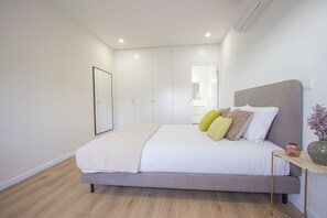Une chambre à coucher moderne avec un lit, une table de chevet et un miroir.
