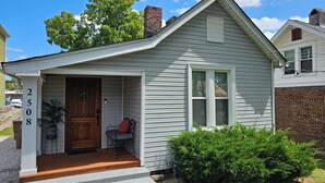 A small, single-story house with a front porch, a wooden door, and a mailbox. - Cozy Cottage @ Trevecca (Nashville)