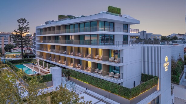 Un hôtel moderne à plusieurs étages, doté de balcons, d’une piscine sur le toit et d’un jardin aménagé.