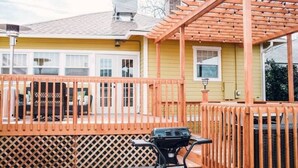 A covered outdoor area with a wooden deck and a grill. - Best Location downtown GJ - Beautifully updated 2 Bedroom! (Grand Junction)