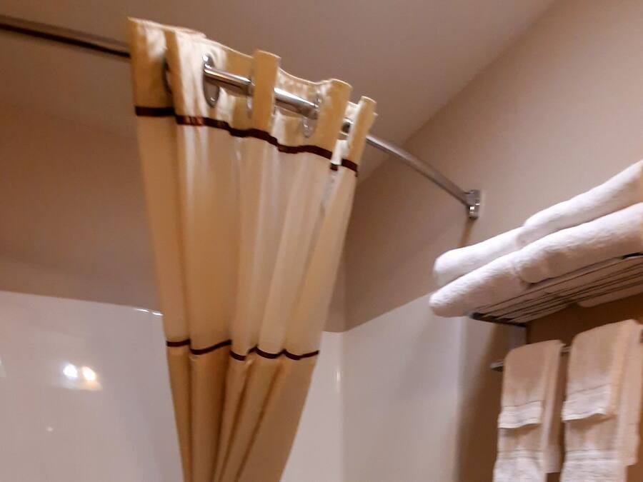 A bathroom with a bathtub, toilet, and shower curtain.