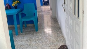 A narrow hallway with a blue wall, a white door with glass panels, and a tiled floor. - APARTMENT WITH BALCONY ECONOMIC, QUIET, IN COUNTRY HOUSE NEAR THE SEA (SANTA MARTA)