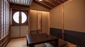A traditional Japanese room with tatami flooring, a low wooden table, and a shoji screen door. - Rinn Gion Hanatouro (Kyoto)