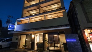 A multi-story hotel with a modern design, featuring balconies on the upper floors and a well-lit entrance. - Rinn Gion Hanatouro (Kyoto)