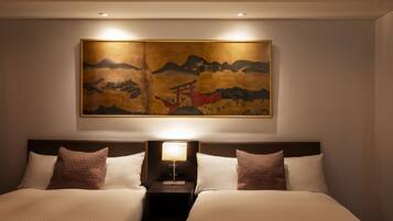 A hotel room with two beds, a nightstand, a lamp, and a large painting on the wall.