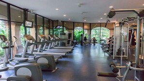 Un gimnasio con cintas de correr, elípticas y equipo de levantamiento de pesas.