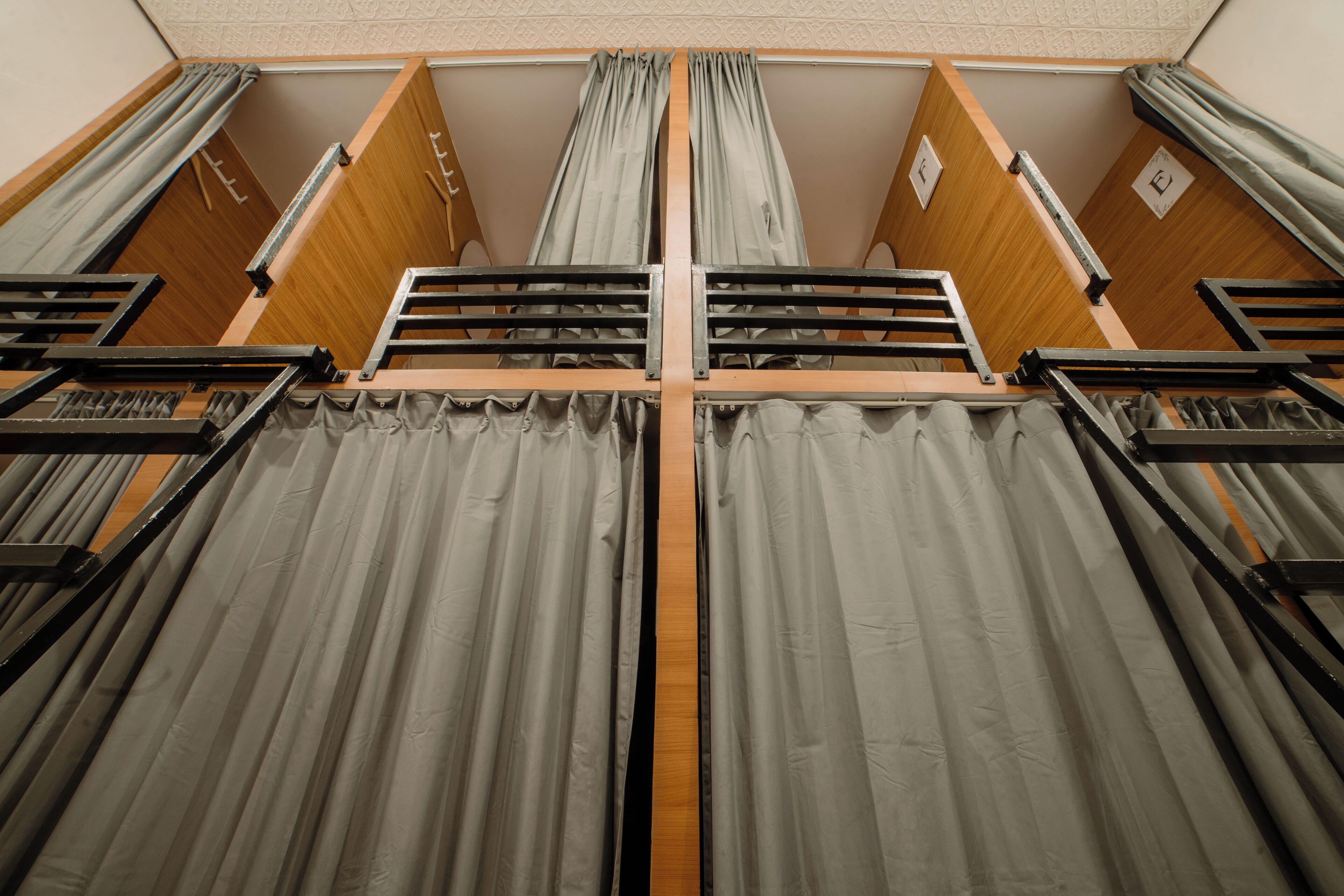 A room with a bunk bed, wooden paneling, and curtains.