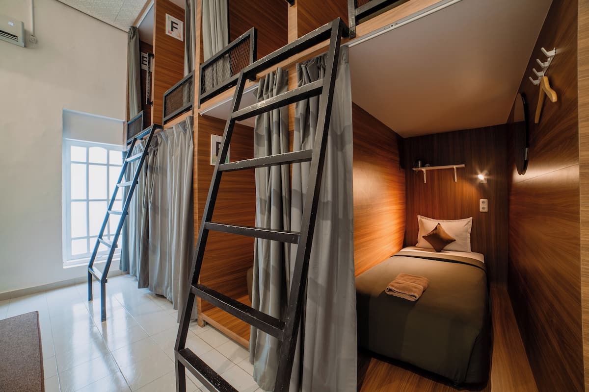 A bedroom with a bunk bed, a ladder, and a window.