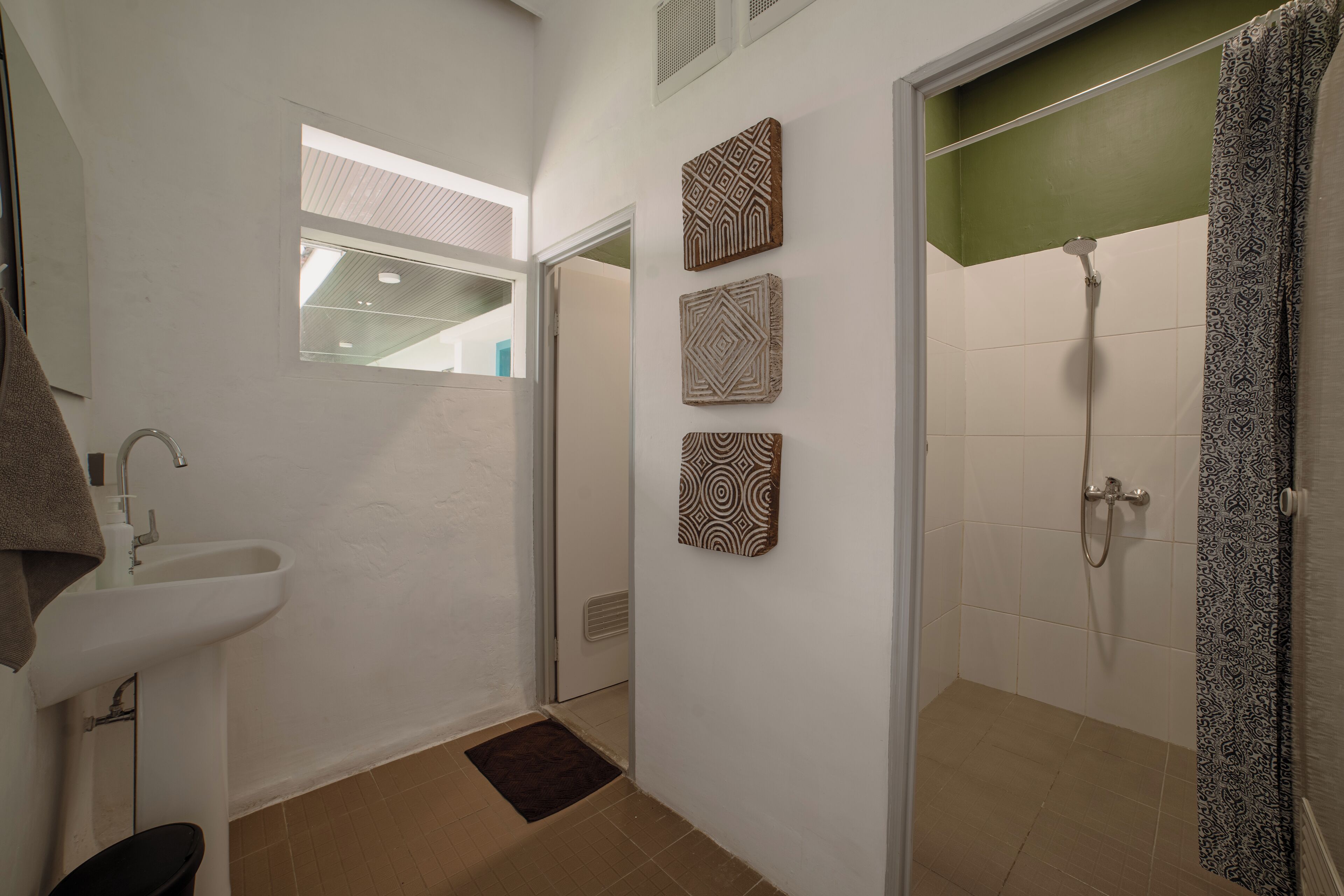 A bathroom with a sink, a shower, and decorative wall art.