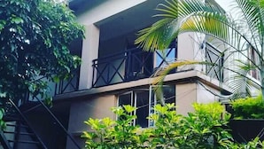A modern building with a balcony, a staircase, and lush greenery. - Shamba Lodge (Kitwe)