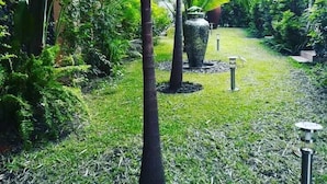A lush garden with various plants and a large decorative vase. - Shamba Lodge (Kitwe)