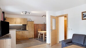Um espaço compacto com cozinha compacta, área de refeições e zona de estar.