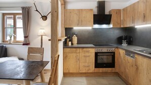 Eine moderne Küche mit Holzausstattung, Backofen und einem Essbereich mit Tisch und Stühlen.