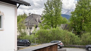 Eine Wohnstraße mit Häusern, parkenden Autos und einem Holzzaun.
