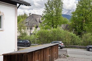 Una calle residencial con casas, autos estacionados y una valla de madera.