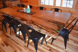 Una mesa de madera con sillas, una caja de pañuelos y una bandeja.