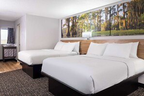 A hotel room with two beds, a large window, a painting of a forest, and a small desk with a lamp. - Days Inn by Wyndham Salisbury, NC (Salisbury)