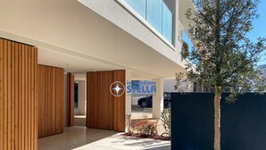 A modern building with a wooden facade, a logo, and a car parked outside. - Residence Medusa - 6 (Lido di Jesolo)