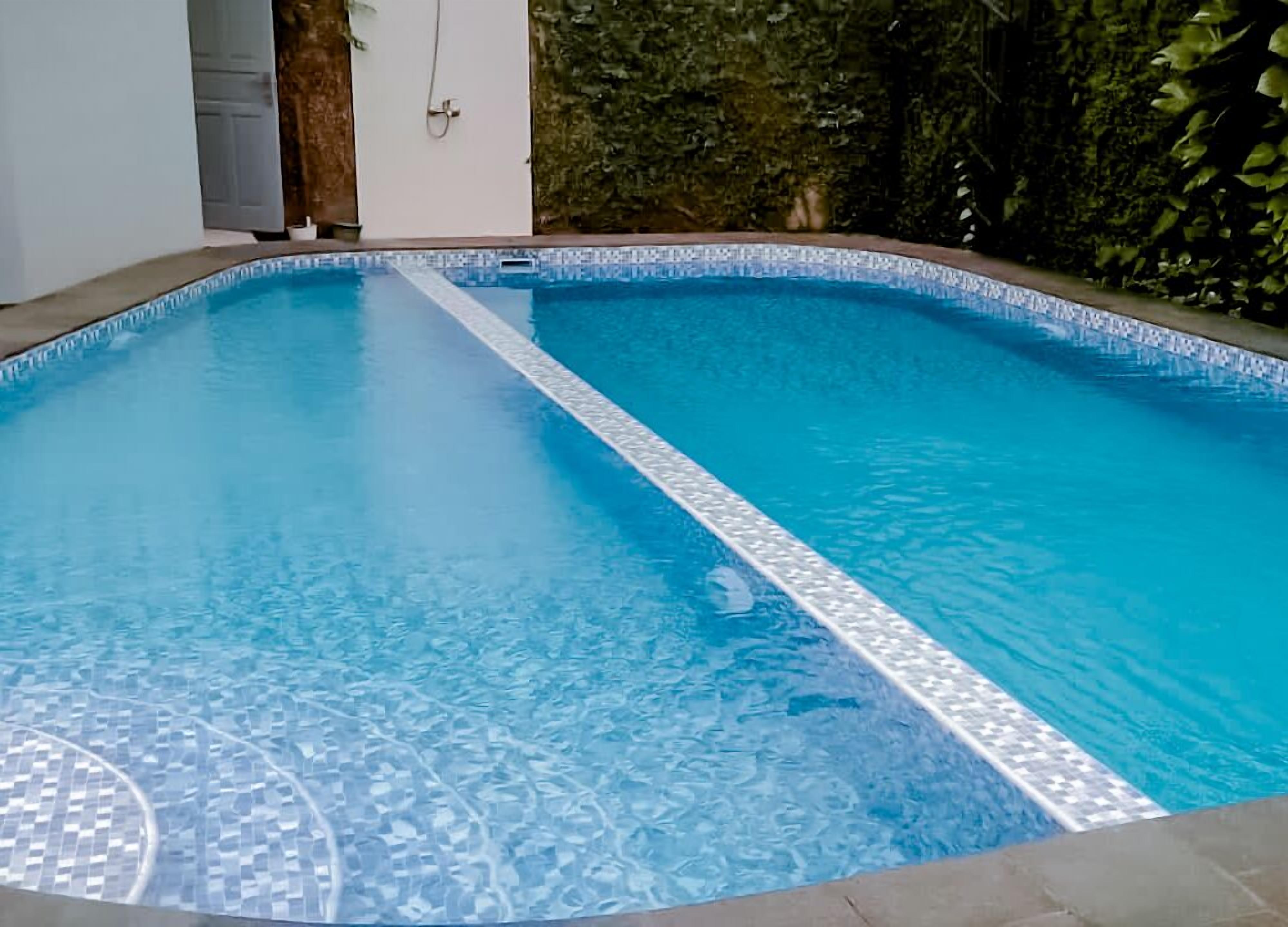 A swimming pool with a tiled edge and a clear blue interior.