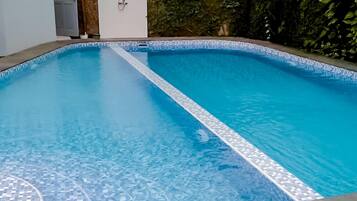 A swimming pool with a tiled edge and a clear blue interior.