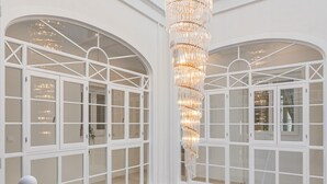 Un intérieur somptueux, avec de grandes fenêtres en arc de cercle et un imposant lustre décoratif.