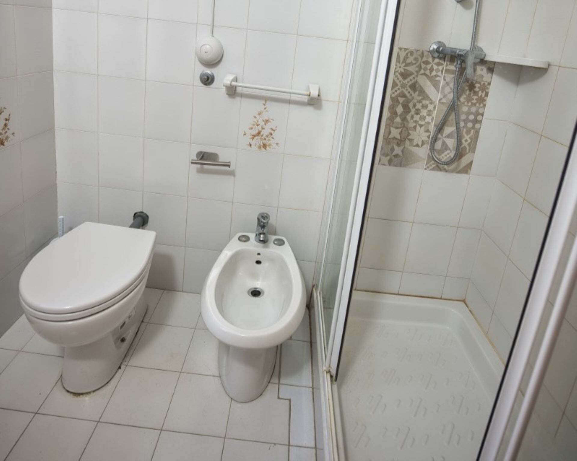 Une salle de bain comprenant des toilettes, un bidet et un espace douche.